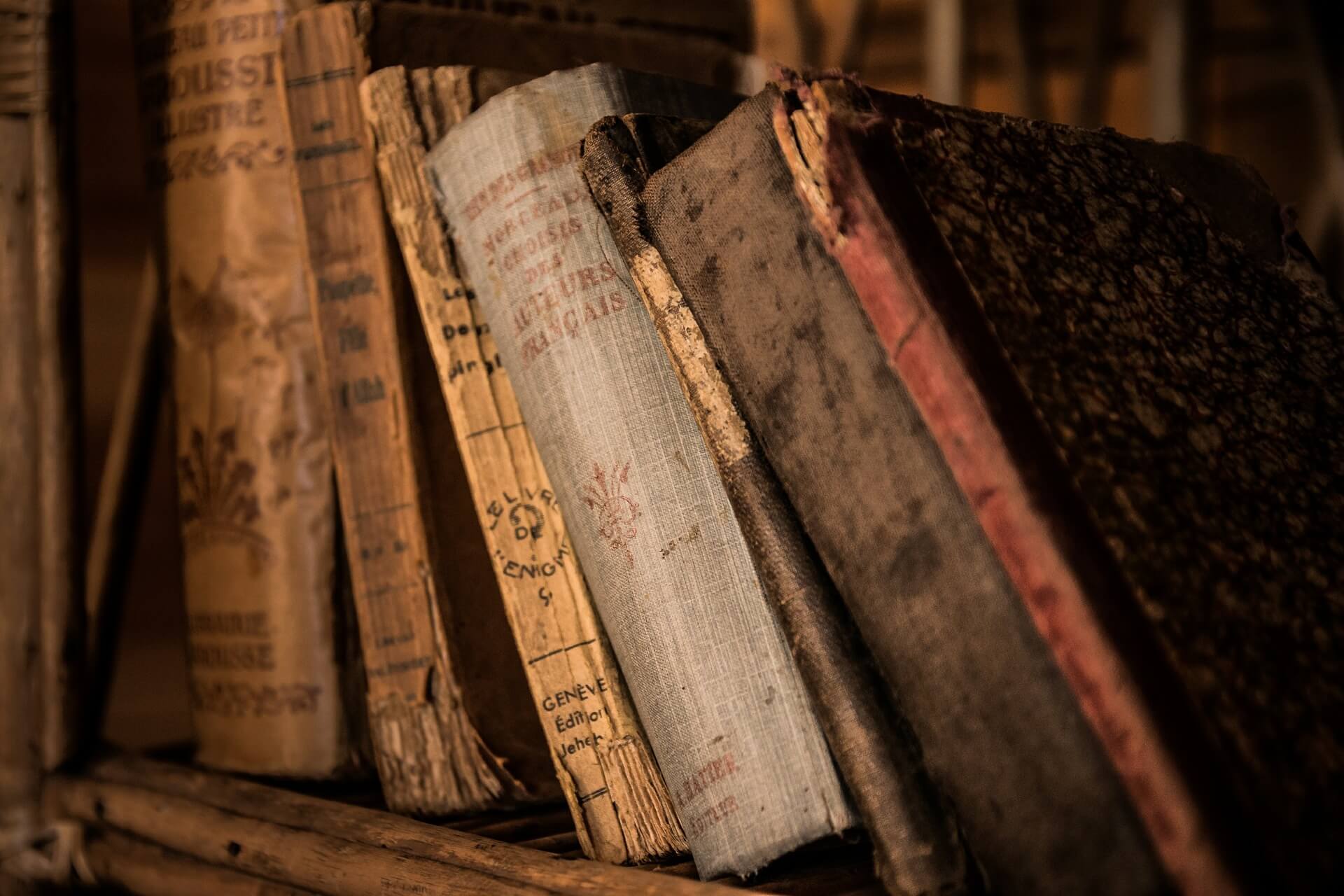 Alte Bücher lehnen in einem Bücherregal schräg übereinander